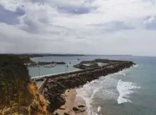 Vista costeira de Matosinhos com praia, mar e quebra-mar.